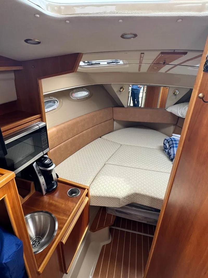 Slide: The Image of 2017 Cutwater C28 cabin interior with bed, sink, and microwave. - 28