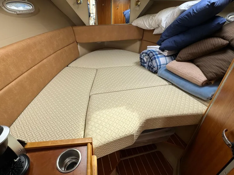 Slide: The Image of 2017 Cutwater C28 cabin with cozy bed, pillows, and wooden interior. - 29