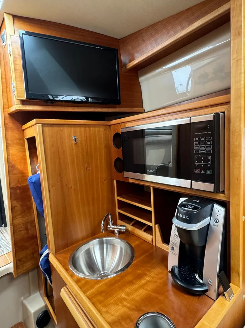 Slide: The Image of 2017 Cutwater C28 interior with sink, microwave, TV, and coffee maker. - 30