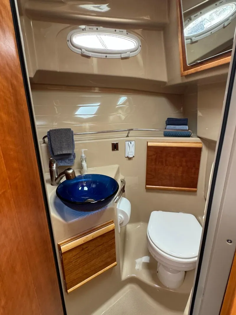 Slide: The Image of 2017 Cutwater C28 boat bathroom with blue sink, toilet, and wooden accents. - 32
