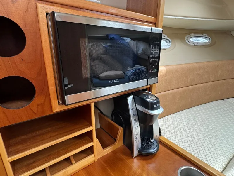 Slide: The Image of 2017 Cutwater C28 interior with microwave, coffee maker, and wooden cabinetry. - 33