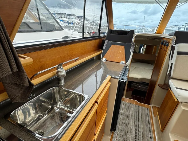 Slide: The Image of Interior of 2017 Cutwater C28 boat with sink, wooden cabinetry, and seating area. - 38