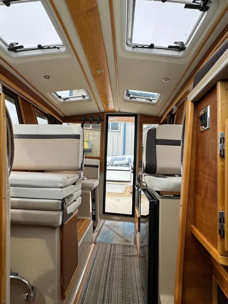 Slide: The Image of Interior of a 2017 Cutwater C28 boat, featuring seating and wooden finishes. - 39