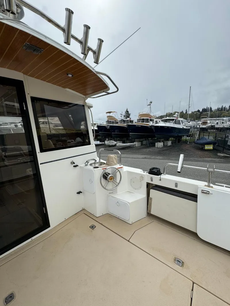 Slide: The Image of 2017 Cutwater C28 boat deck with fishing rod holders, docked at a marina. - 5