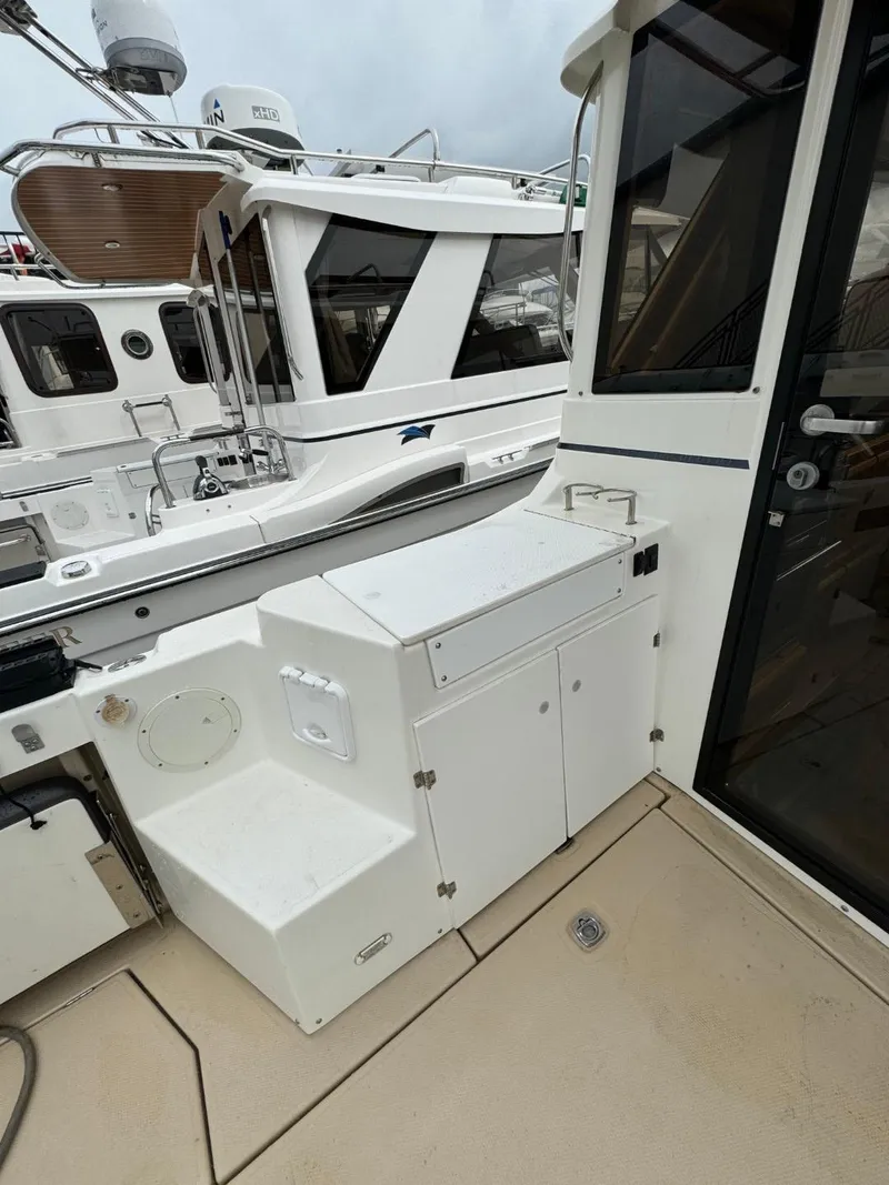 Slide: The Image of 2017 Cutwater C28 boat deck with storage compartment, docked alongside another vessel. - 7