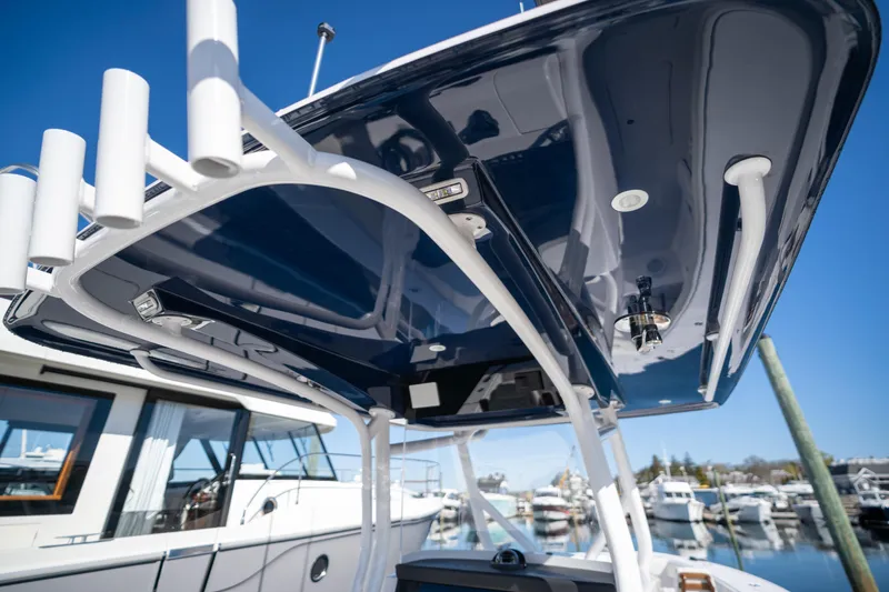 Slide: The Image of 2024 Jupiter 32 boat with sleek blue canopy at marina. - 17