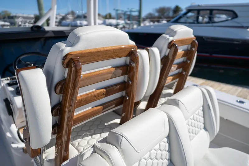 Slide: The Image of Luxury seating on a 2024 Jupiter 32 boat with wooden accents and white upholstery. - 9