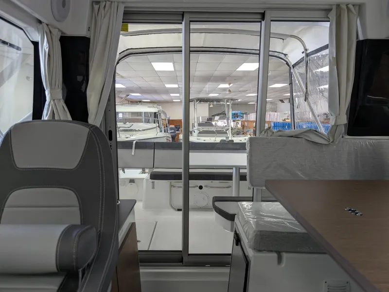 Slide: The Image of Interior view of 2024 Jeanneau NC795 S2 boat, showcasing seating and sliding glass doors. - 9