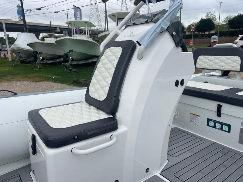 Slide: The Image of 2024 Highfield Sport 460 boat interior with cushioned seating and steering console. - 11