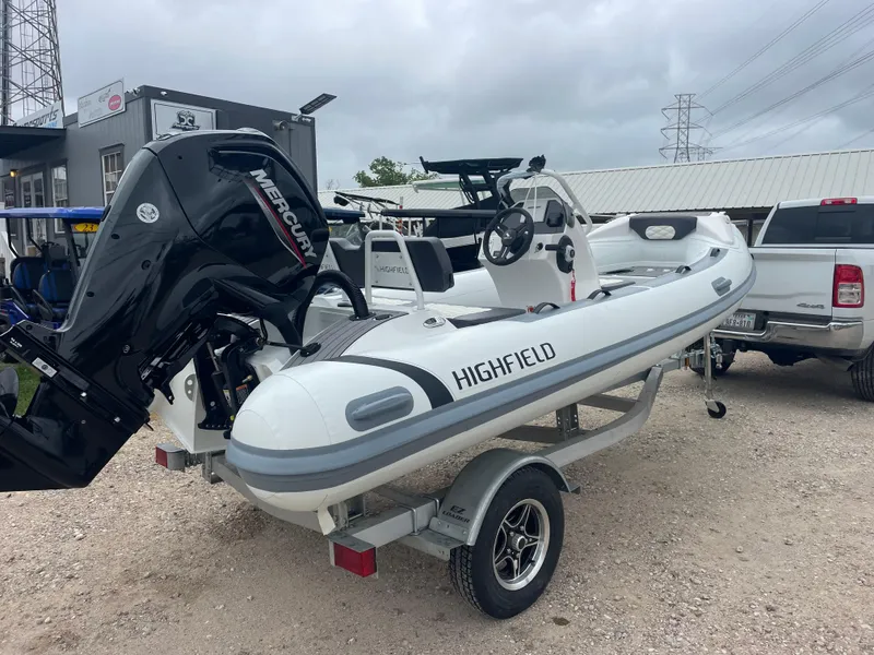 Slide: The Image of 2024 Highfield Sport 460 boat with Mercury engine on trailer, parked outdoors. - 2