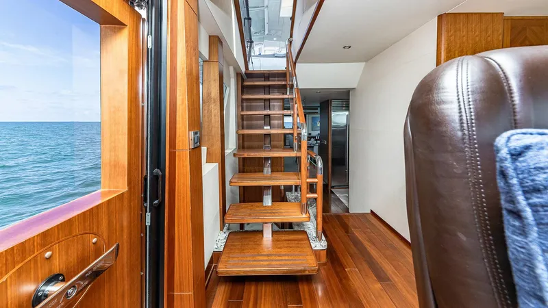 Slide: The Image of Interior of 2015 Ocean Alexander Motoryacht Open Bridge with wooden stairs and ocean view. - 23
