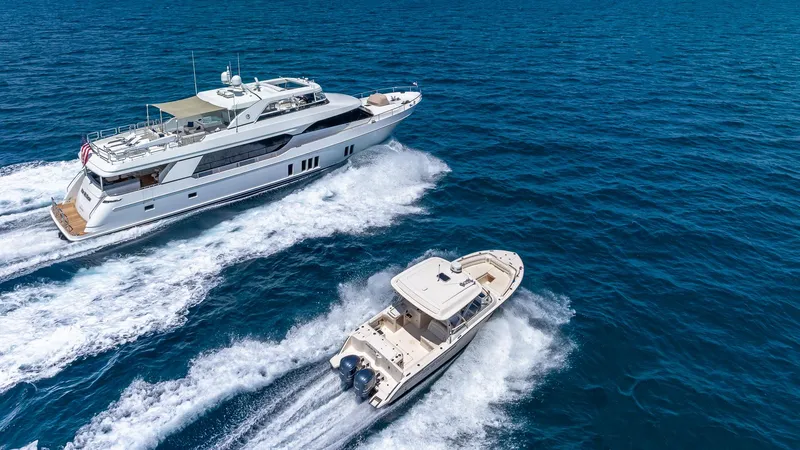 Slide: The Image of 2015 Ocean Alexander Motoryacht Open Bridge cruising alongside a smaller boat on the ocean. - 7