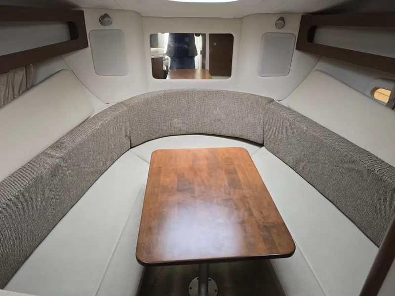 Slide: The Image of Interior cabin of 2015 Sea Ray 260 Sundancer with wooden table and cushioned seating. - 6