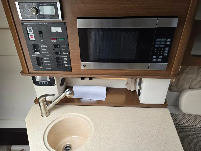 Slide: The Image of 2015 Sea Ray 260 Sundancer galley with microwave, sink, and control panel. - 7