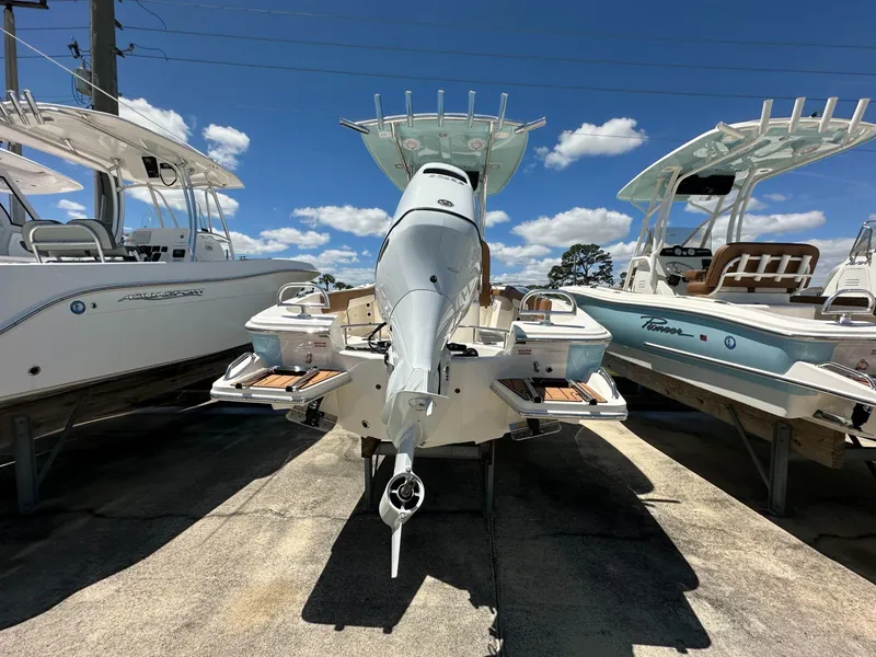 Slide: The Image of 2024 Pioneer 222 Sport Fish boat with powerful 250 engine, docked alongside similar models. - 3