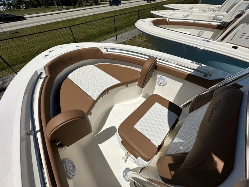 Slide: The Image of 2024 Pioneer 222 Sport Fish boat interior with brown seating and white cooler. - 5