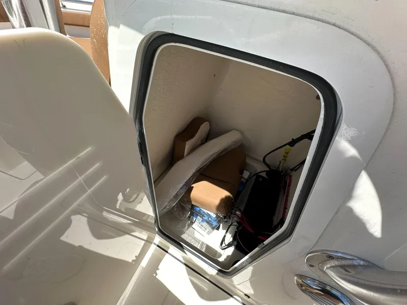 Slide: The Image of 2024 Pioneer 222 Sport Fish boat with tan and white seating, Suzuki engine, and steering wheel. - 7