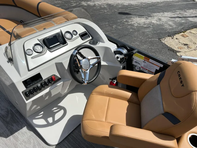Slide: The Image of 2024 Crest Classic LX 220 boat interior with tan seats and modern dashboard. - 14