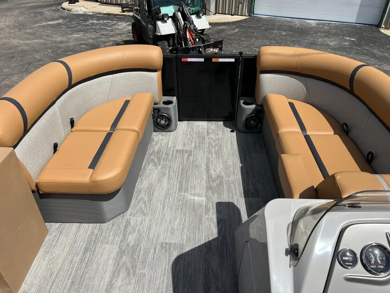 Slide: The Image of 2024 Crest Classic LX 220 pontoon boat interior with tan seating and gray flooring. - 16