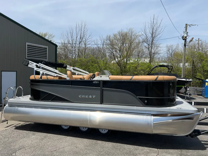 Slide: The Image of 2024 Crest Classic LX 220 pontoon boat with tan seating and black exterior. - 4