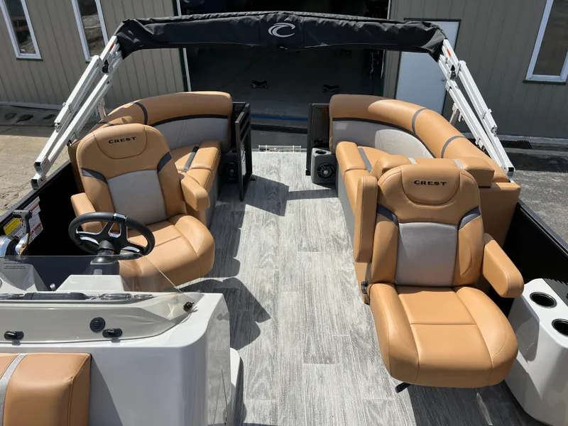 Slide: The Image of 2024 Crest Classic LX 220 pontoon boat with tan leather seating and modern interior. - 9