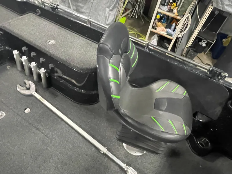 Slide: The Image of 2020 Nitro ZV21 boat interior with black and green seat, rod holders, and storage. - 11