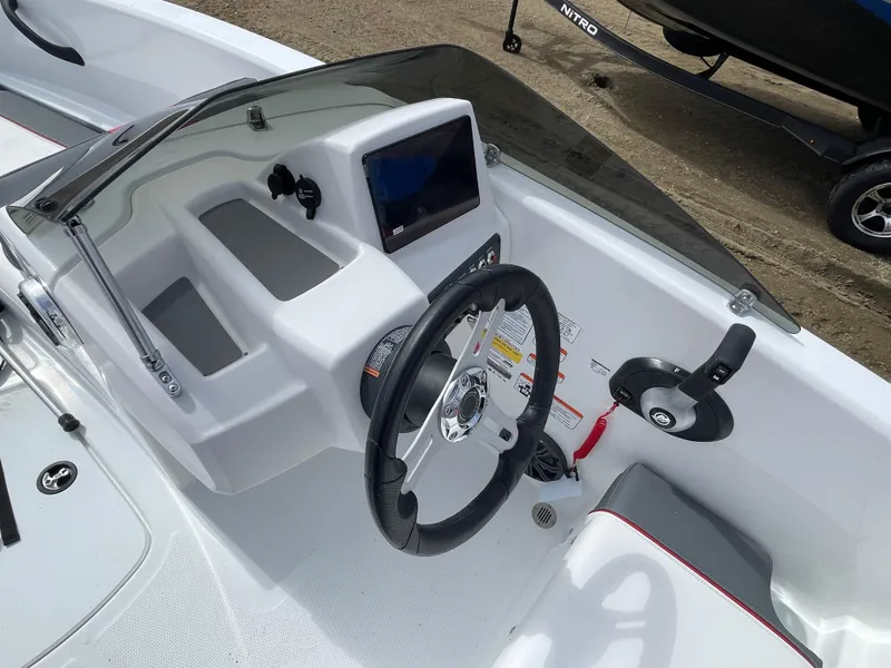 Slide: The Image of 2024 Tahoe T16 boat dashboard with steering wheel and control panel. - 12