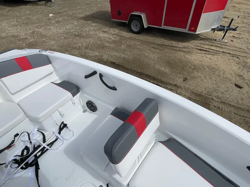Slide: The Image of 2024 Tahoe T16 boat interior with red and gray seating, parked on sandy ground. - 16