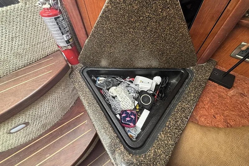 Slide: The Image of Storage compartment on 2006 Sea Ray 44 Sundancer boat with miscellaneous items and fire extinguisher nearby. - 21