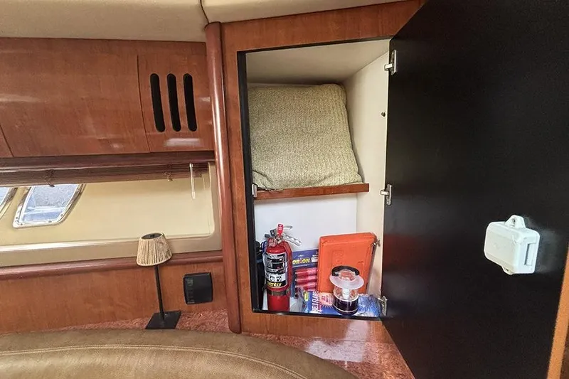 Slide: The Image of Cabinet interior on 2006 Sea Ray 44 Sundancer with fire extinguisher and supplies. - 22
