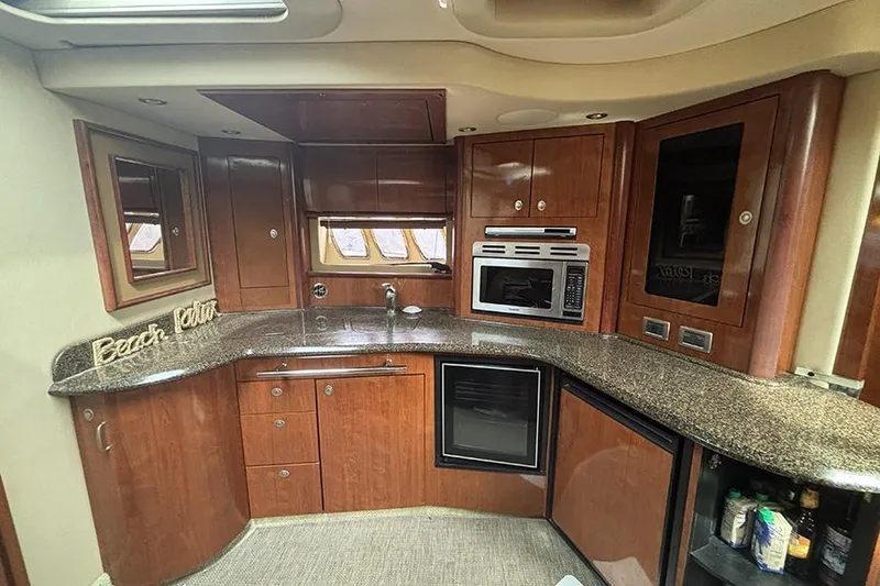 Slide: The Image of Luxurious 2006 Sea Ray 44 Sundancer yacht kitchen with wood cabinetry and modern appliances. - 23