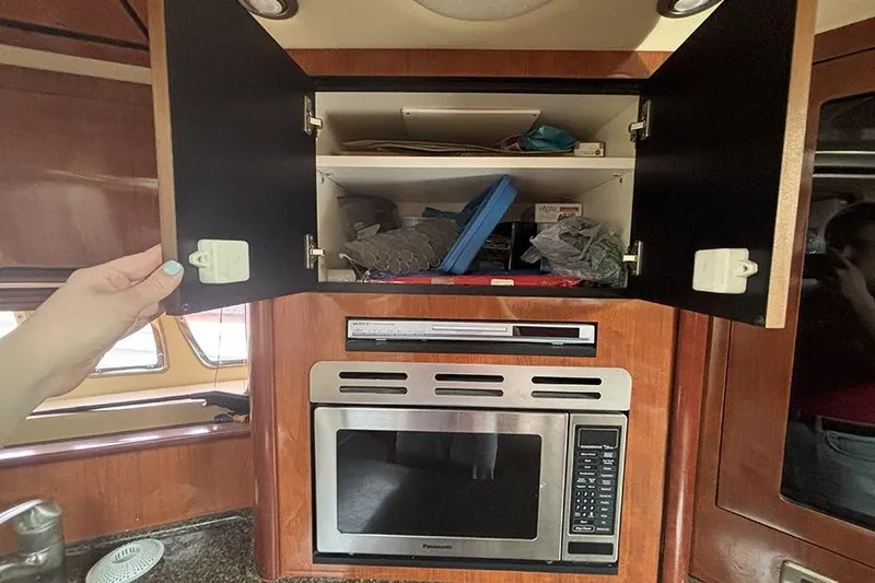 Slide: The Image of Interior of 2006 Sea Ray 44 Sundancer showing open cabinet and microwave. - 24