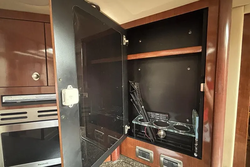 Slide: The Image of Open cabinet in 2006 Sea Ray 44 Sundancer yacht interior, showing storage space and electronics. - 25