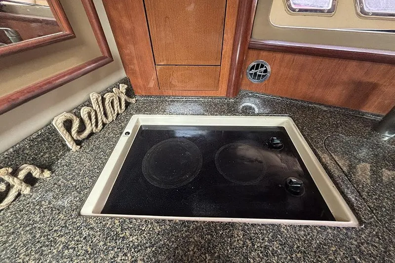 Slide: The Image of 2006 Sea Ray 44 Sundancer kitchen with stove and "Relax" decor. - 26