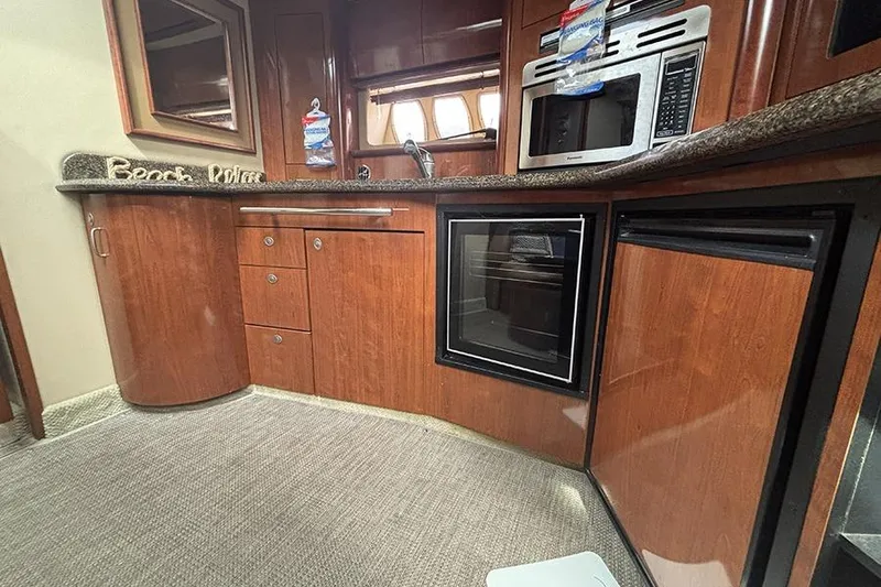 Slide: The Image of Luxurious 2006 Sea Ray 44 Sundancer yacht kitchen with wood cabinetry and modern appliances. - 29