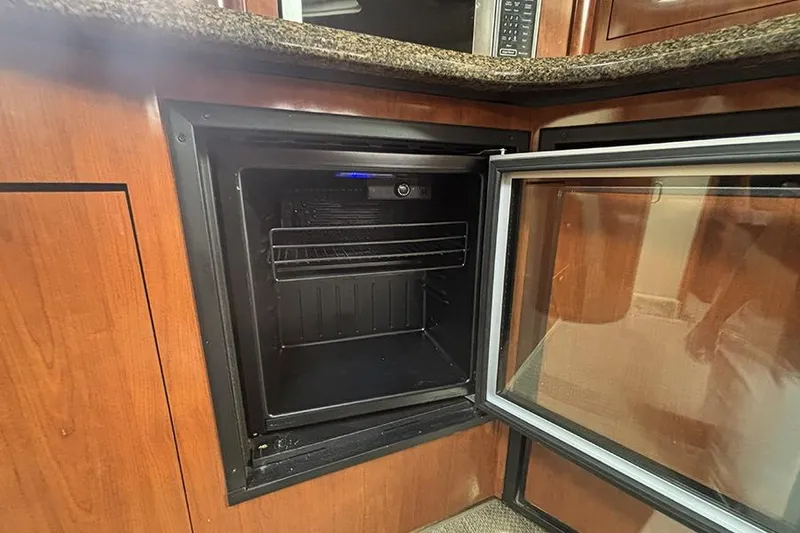 Slide: The Image of Open mini fridge inside 2006 Sea Ray 44 Sundancer yacht kitchen area. - 31