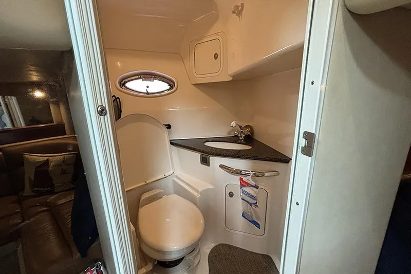 Slide: The Image of 2006 Sea Ray 44 Sundancer bathroom with toilet, sink, and porthole window. - 38