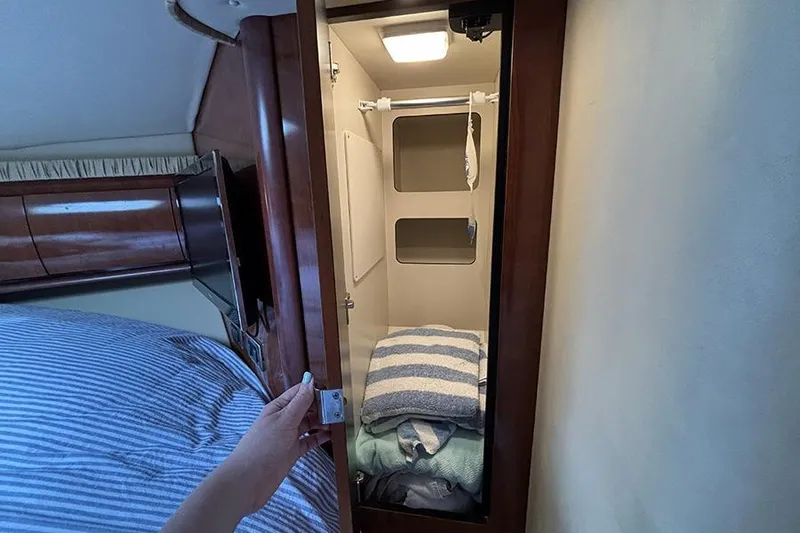 Slide: The Image of Open closet with folded towels inside a 2006 Sea Ray 44 Sundancer yacht cabin. - 42
