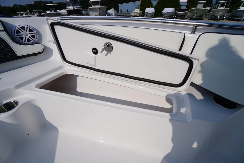 Slide: The Image of 2026 Tidewater 210 CC Adventure boat storage compartment with open hatch and speaker. - 15