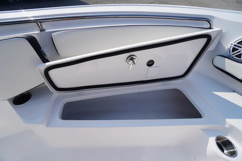Slide: The Image of 2026 Tidewater 210 CC Adventure boat storage compartment with open hatch and key lock. - 16