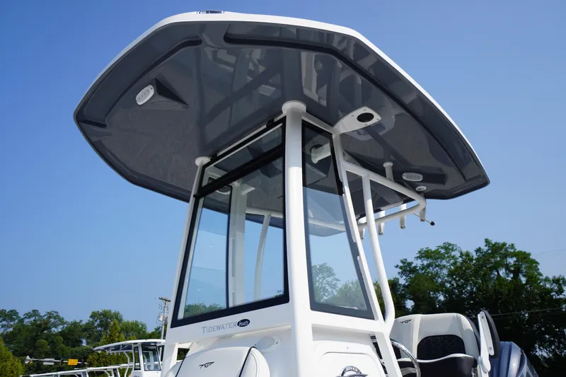 Slide: The Image of 2026 Tidewater 210 CC Adventure boat with T-top against clear blue sky. - 2