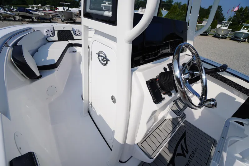 Slide: The Image of 2026 Tidewater 210 CC Adventure boat interior with steering wheel and seating area. - 20
