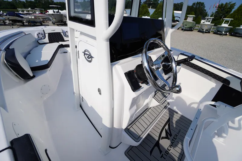 Slide: The Image of 2026 Tidewater 210 CC Adventure boat interior with steering wheel and seating area. - 23