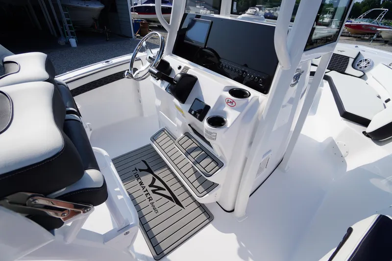 Slide: The Image of 2026 Tidewater 210 CC Adventure boat interior with steering console and seating. - 24