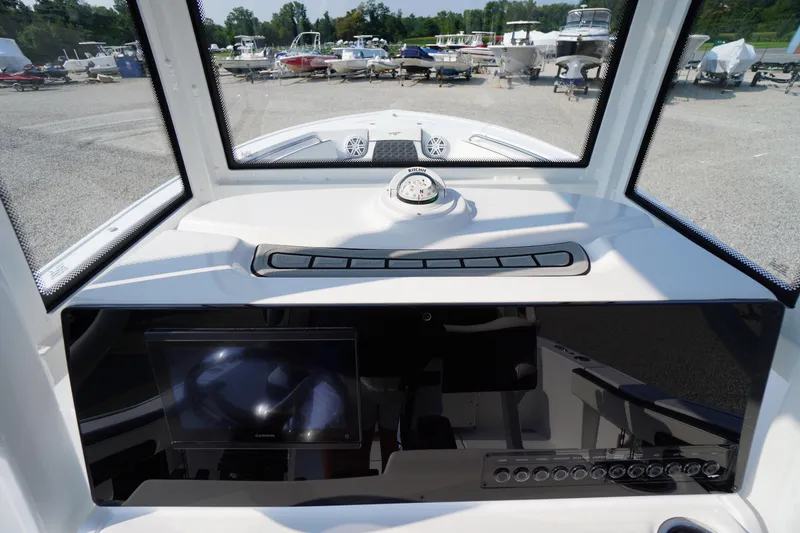 Slide: The Image of 2026 Tidewater 210 CC Adventure boat dashboard with compass and navigation screen. - 26