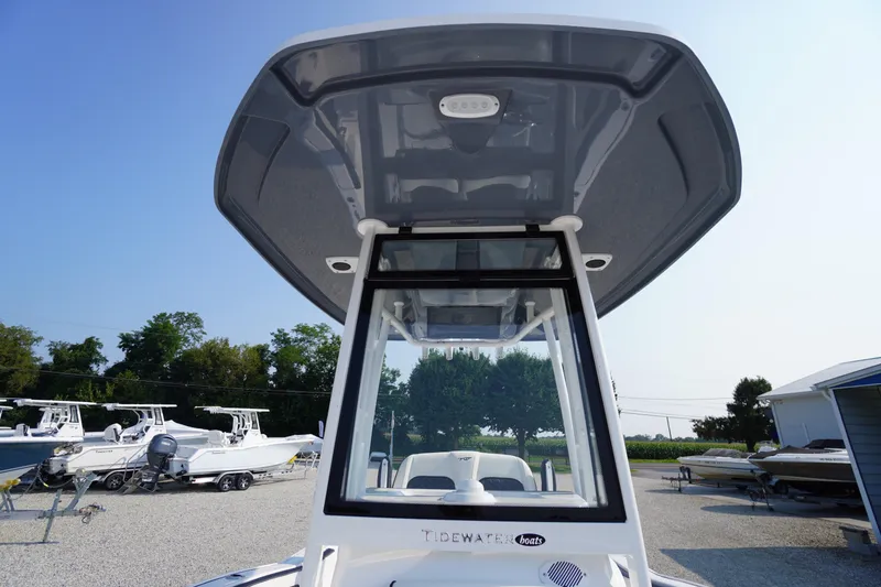 Slide: The Image of 2026 Tidewater 210 CC Adventure boat with T-top, parked outdoors. - 29