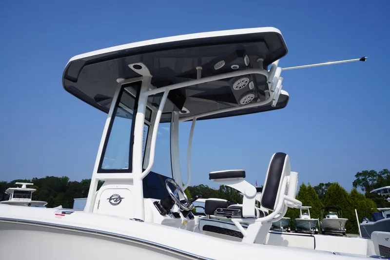 Slide: The Image of 2026 Tidewater 210 CC Adventure boat with T-top and seating, under clear blue sky. - 5