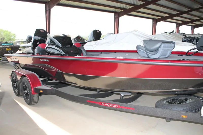 Slide: The Image of 2024 Vexus AVX1980C boat in red and black, parked under a metal canopy. - 3