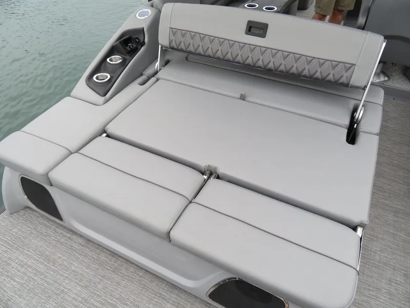 Slide: The Image of 2024 Bennington 23RSB boat with gray lounge seating by the water. - 11