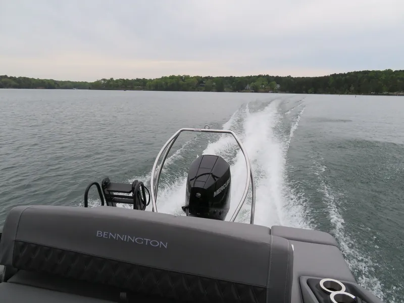 Slide: The Image of Bennington 23RSB 2024 boat cruising on a calm lake. - 13